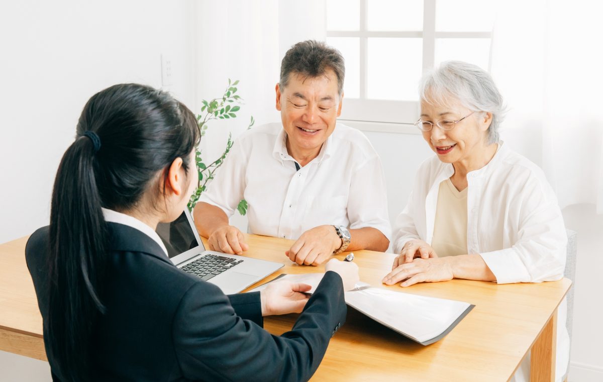 泉大津市の長屋の買取について相談するご夫婦と株式会社GEEZの担当者