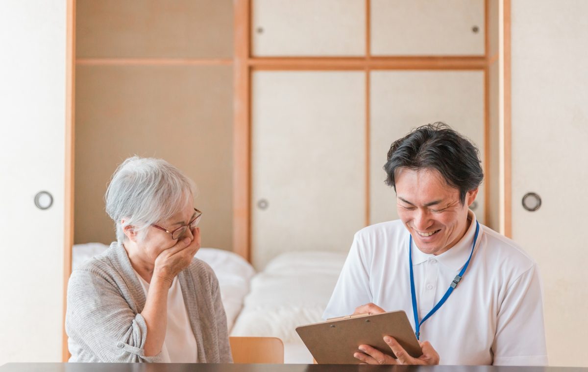 泉佐野市の長屋の買取について相談するご夫婦と株式会社GEEZの担当者