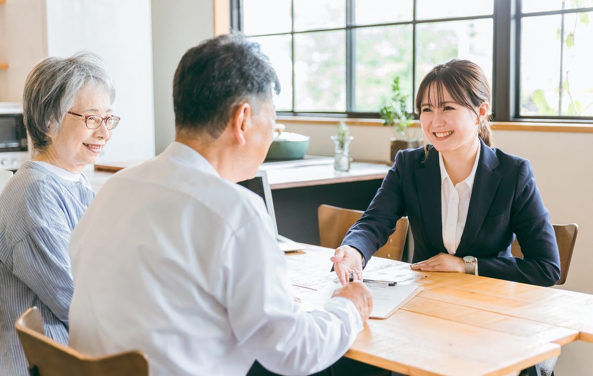 河南町の長屋の買取について相談するご夫婦と株式会社GEEZの担当者
