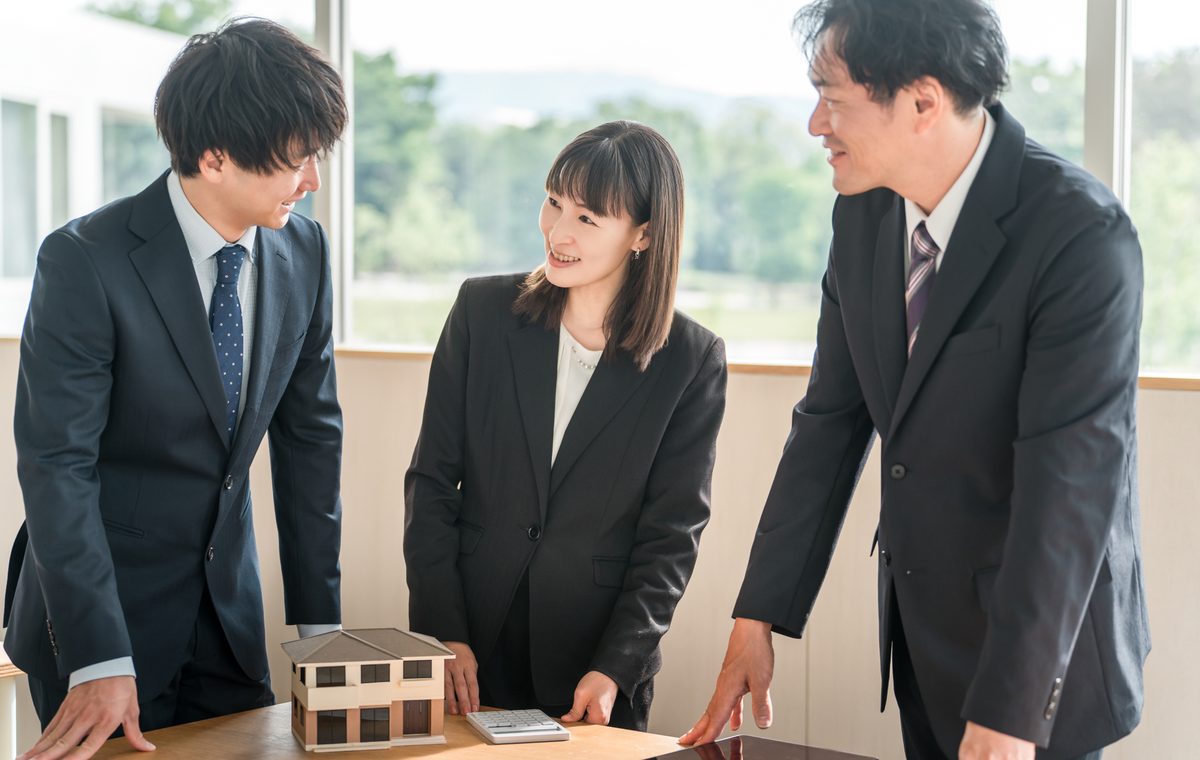 熊取町の長屋の買取について相談するご夫婦と株式会社GEEZの担当者