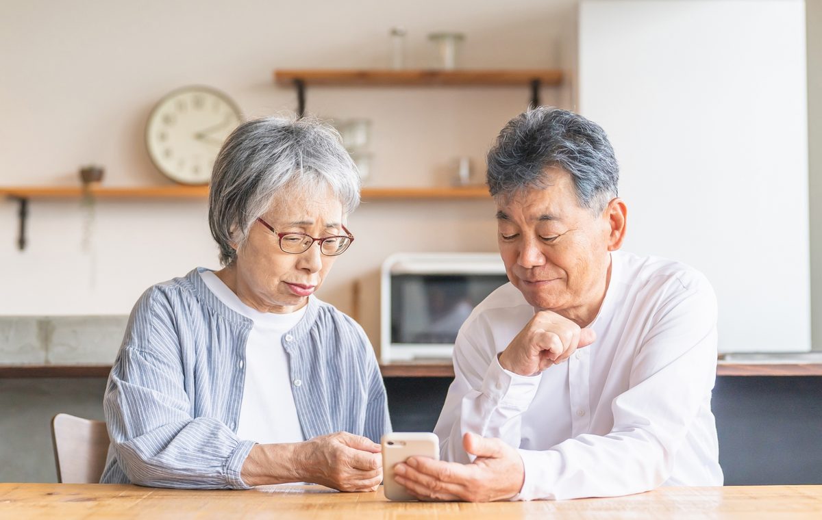 箕面市の長屋の買取について相談するご夫婦と株式会社GEEZの担当者