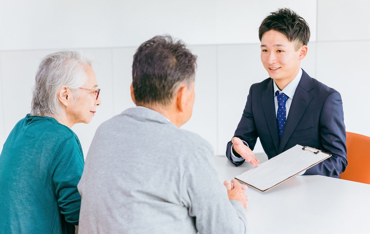 摂津市の長屋の買取について相談するご夫婦と株式会社GEEZの担当者