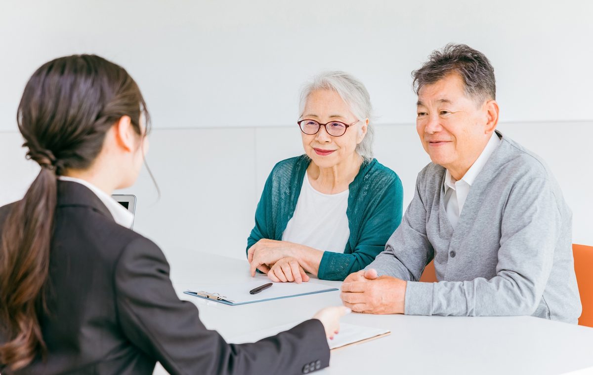 大阪市鶴見区の長屋の買取について相談するご夫婦と株式会社GEEZの担当者