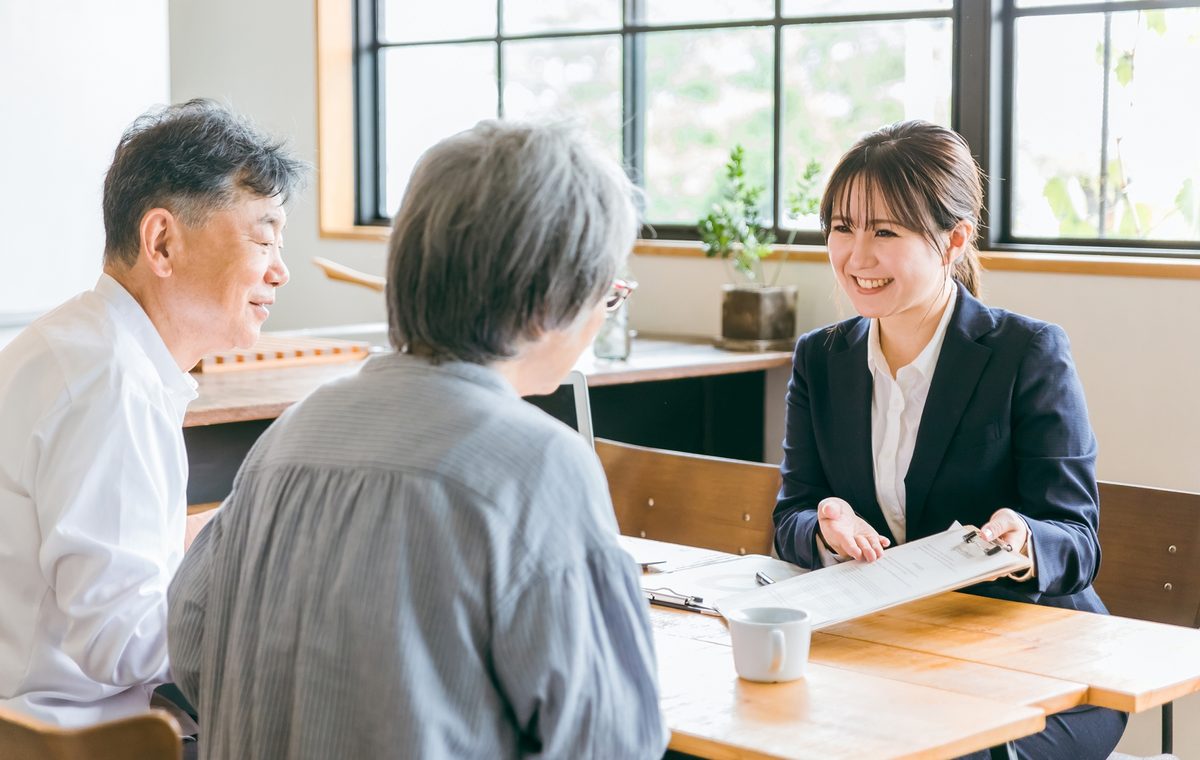 大阪市淀川区の長屋の買取について相談するご夫婦と株式会社GEEZの担当者
